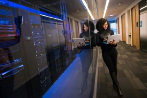 woman on laptop by corporate server
